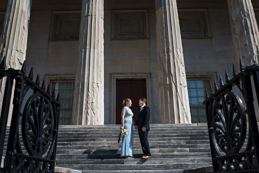 Newlyweds hold hands on the steps of the second bank of America in Philadelphia.